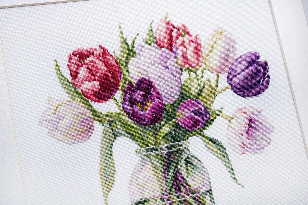 Cross-stitched design of tulips in a jar on fabric
