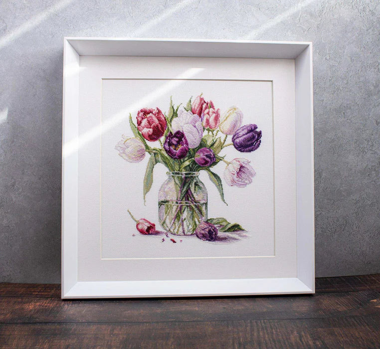 Framed artwork of a bouquet of tulips on a textured wall.