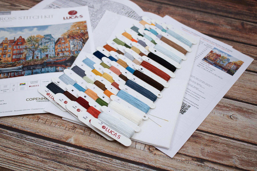 Color swatches and cross stitch pattern on a wooden surface