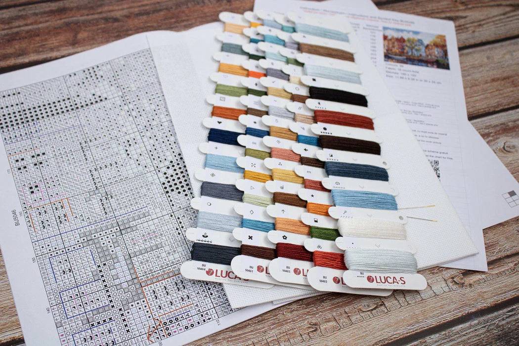 Color swatch with Lucas brand labels on a wooden surface with patterned paper underneath
