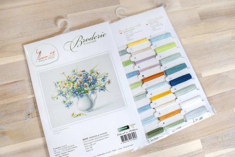 Embroidery kit with color chart and design illustration on a wooden surface