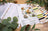 Embroidery thread set with color chart and forest animal designs on a wooden surface with greenery.