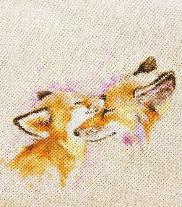 Cross-stitched design of two foxes on fabric
