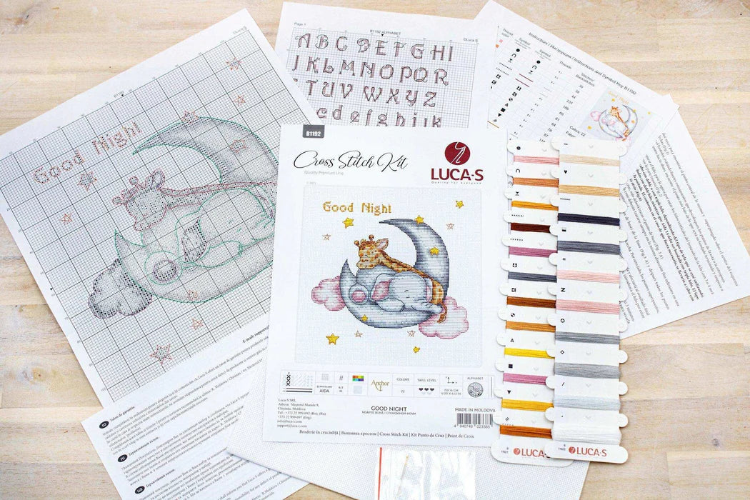 Cross-stitch kit with pattern, thread colors, and design on a wooden surface