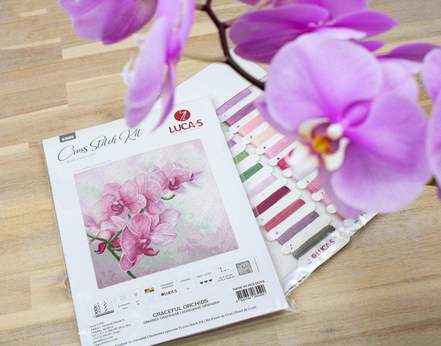 Lucas cross stitch kit with pink orchid design on a wooden surface