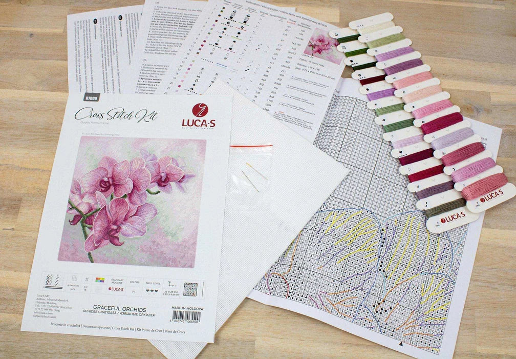 Cross stitch kit with pattern, color chart, and fabric on a wooden surface
