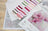 Cross stitch pattern with color swatches and floral design on a wooden surface