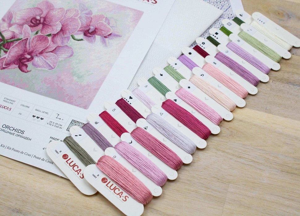 Set of colorful thread samples with 'Luca's' branding on a wooden surface.