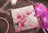Embroidery hoop with pink floral design on a wooden surface