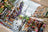 Cross-stitched city scene with Eiffel Tower and street vendors.
