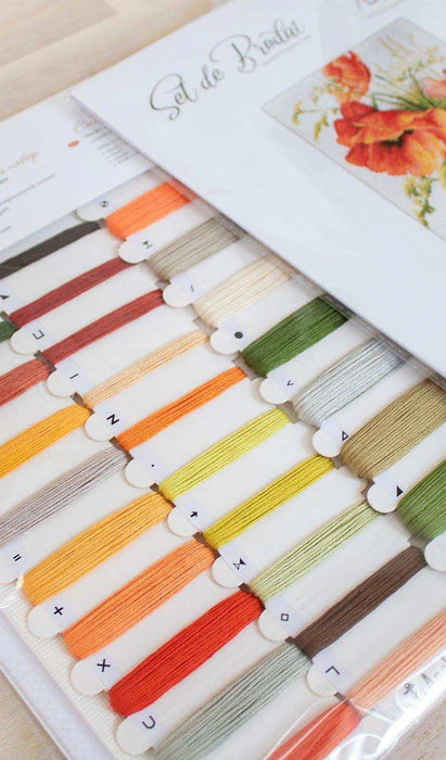 Set of colorful embroidery threads in a box with floral design on lid