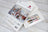 Cross stitch kit packaging with Santa's Cottage design on a wooden surface