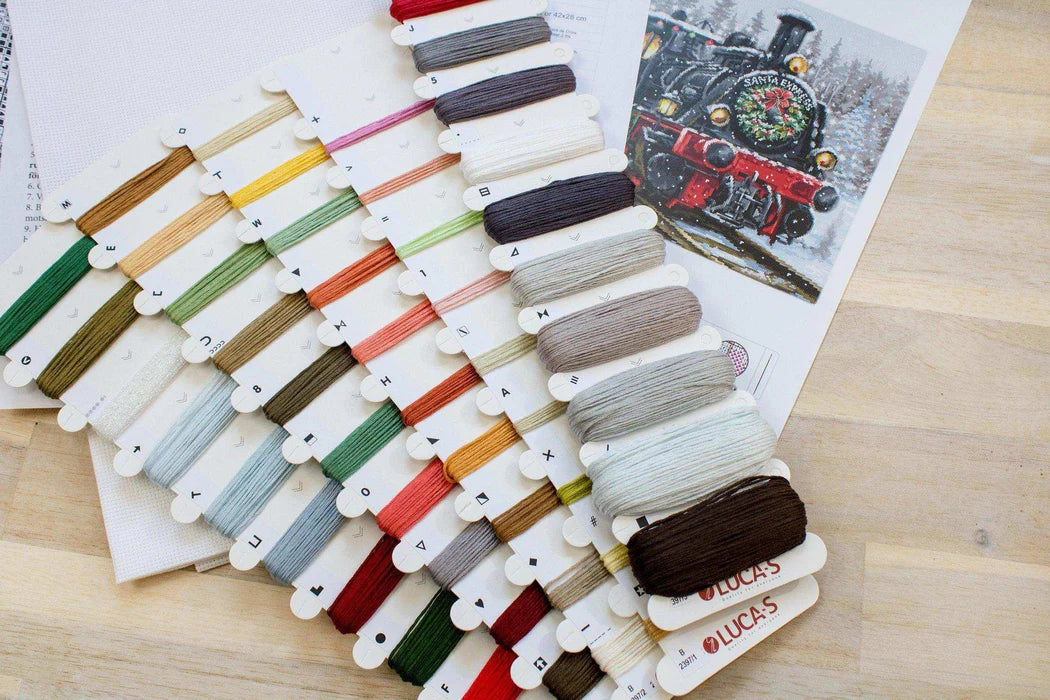 Color swatch card with embroidery threads on a wooden surface
