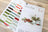 Set of embroidery threads and design sheet on a wooden surface