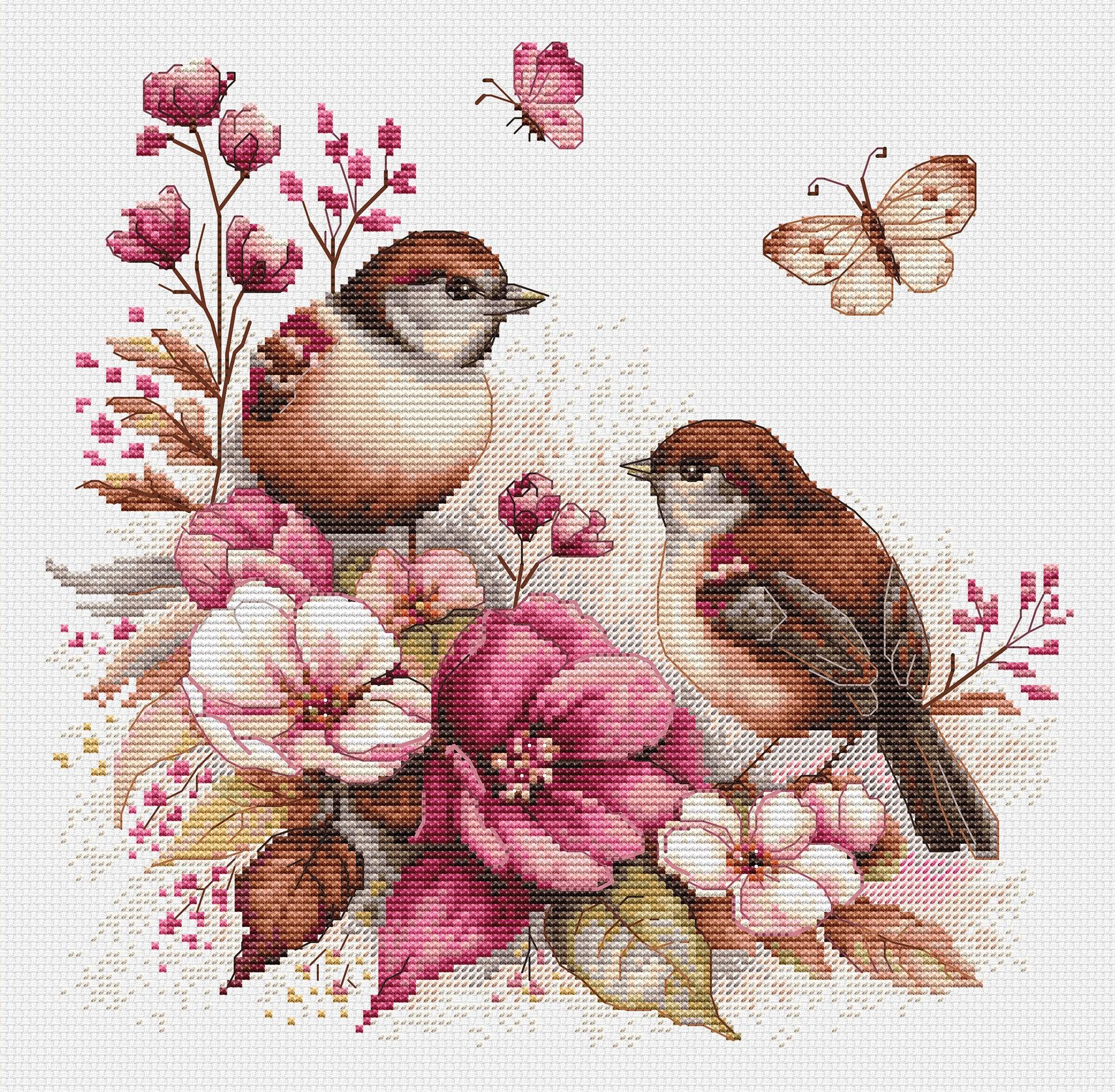 Cross-stitched design of two birds and pink flowers on a white background