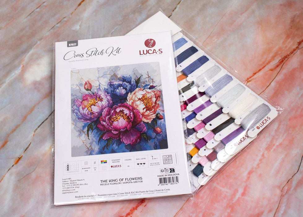 Lucas cross-stitch kit with floral design and color chart on a marble surface