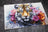 Artistic depiction of a tiger surrounded by colorful flowers on a textured surface.