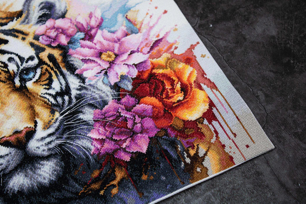 Cross-stitch pattern with a tiger and flowers on fabric